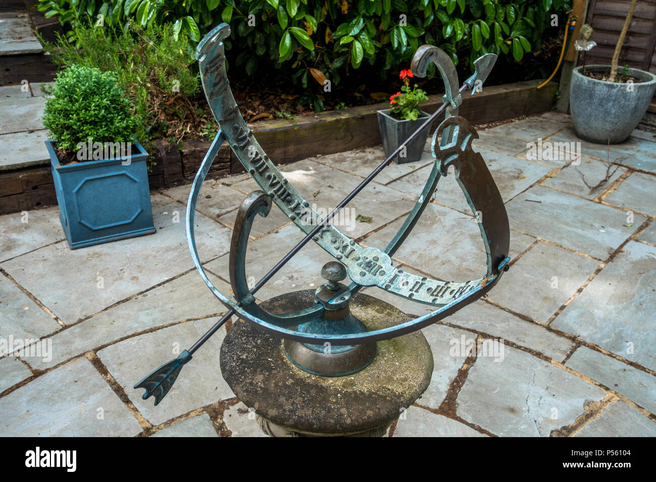 Una sfera Amillary style meridiana è un decorativo punto focale in un giardino. Foto Stock