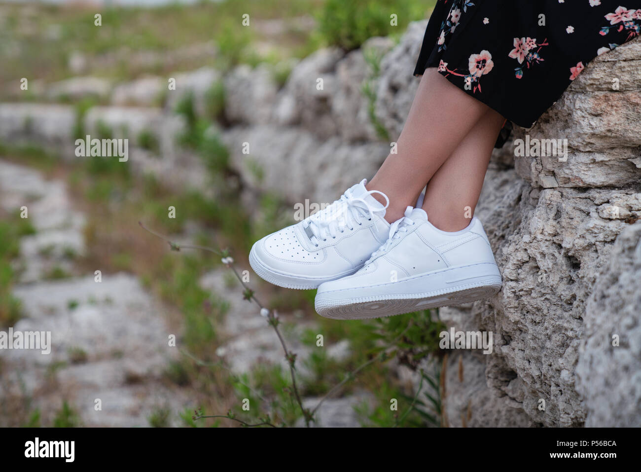Sneakers femmina. Femmina bianca scarpe sui piedi. Sneakers closeup Foto Stock