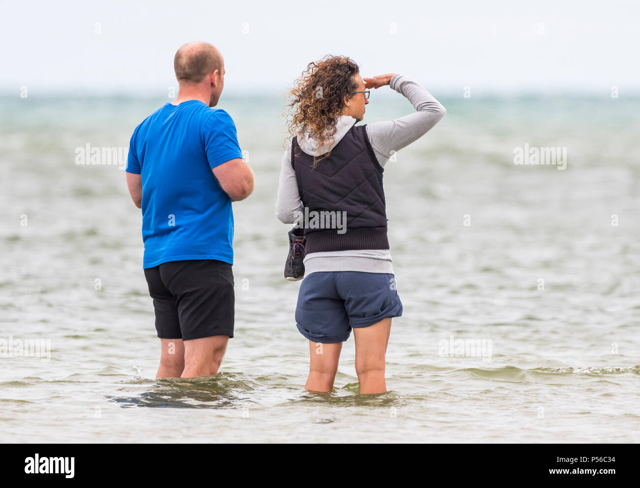 Paio di persone che indossano pantaloncini imbottitura in mare. L uomo e la donna imbottitura nell'oceano in pantaloncini corti. Foto Stock