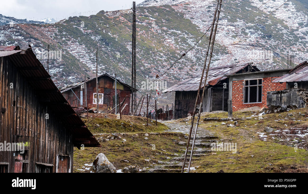 Una nebbiosa serata con borgo collinare case a valle Nathang, India. Foto Stock