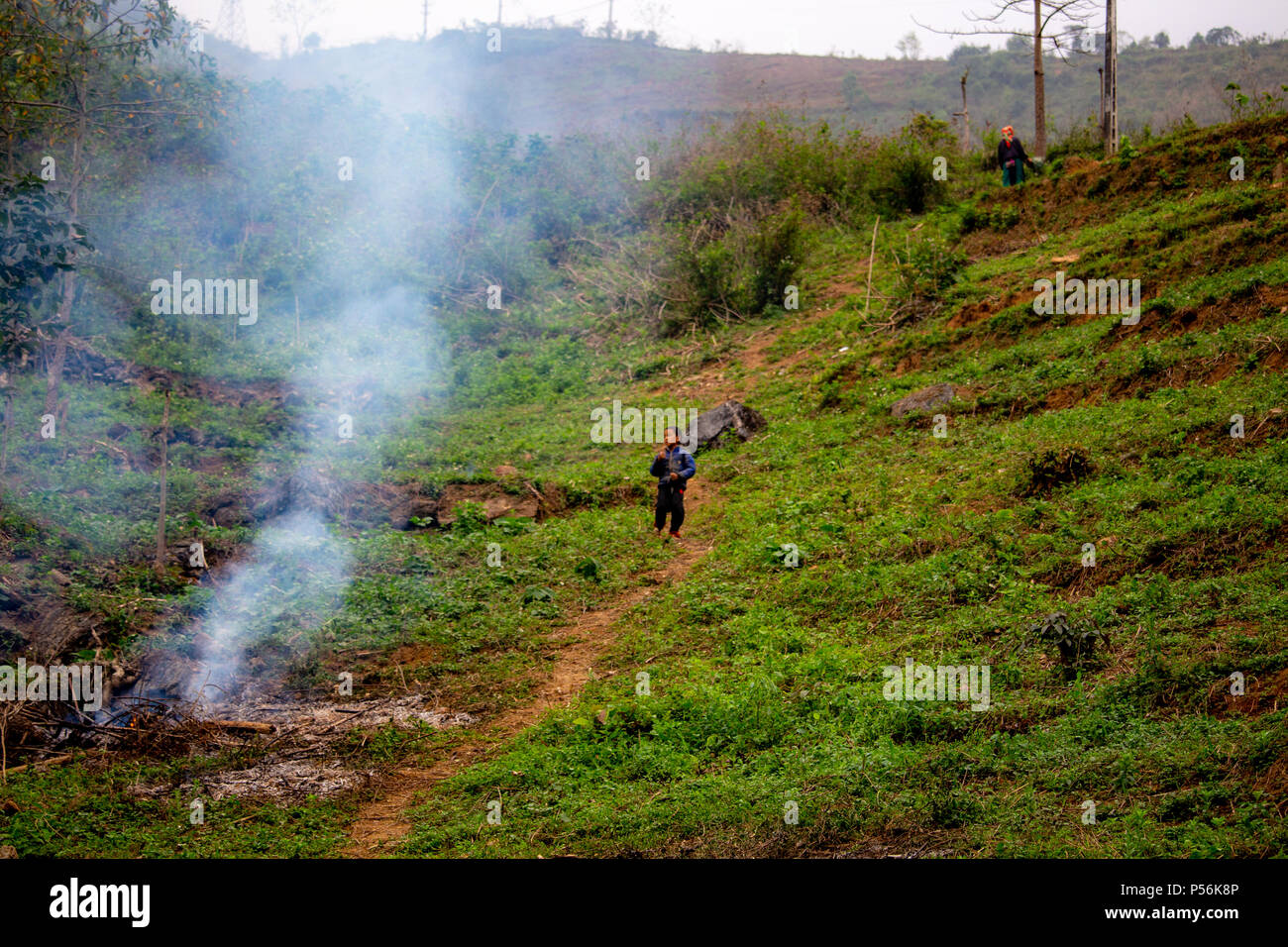 Ha Gian, Vietnam - Marzo 18, 2018: locale popolazione nomade la masterizzazione di un campo nel nord del Vietnam. Il fumo e la nebbia in questa regione sono diventati un grave en Foto Stock