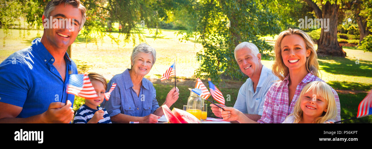 Ritratto di famiglia avente un picnic e azienda bandiera americana Foto Stock