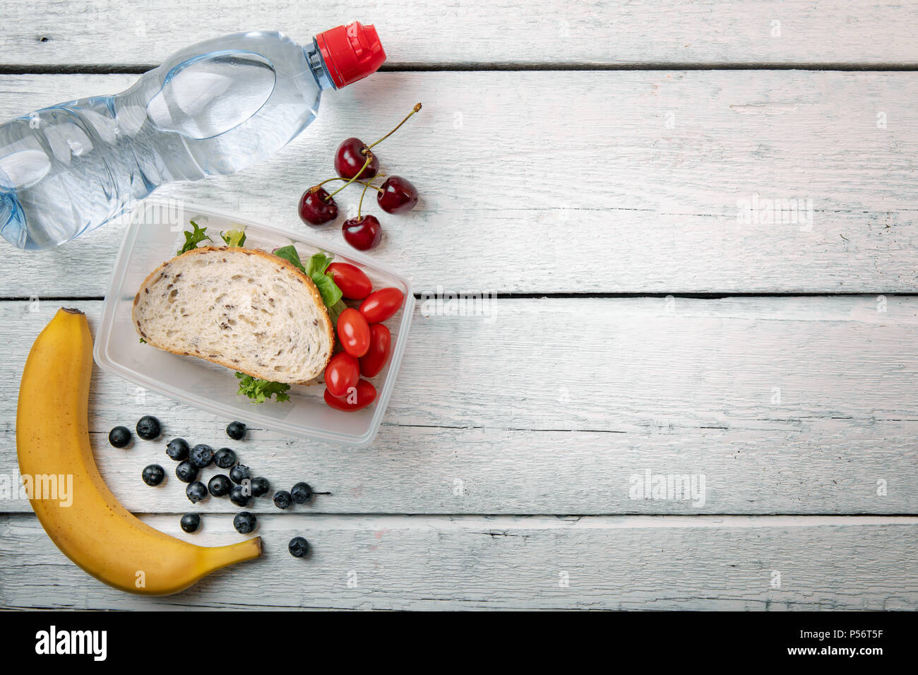Scatola di pranzo con panini e frutta bianca sul tavolo di legno con lo spazio di copia Foto Stock