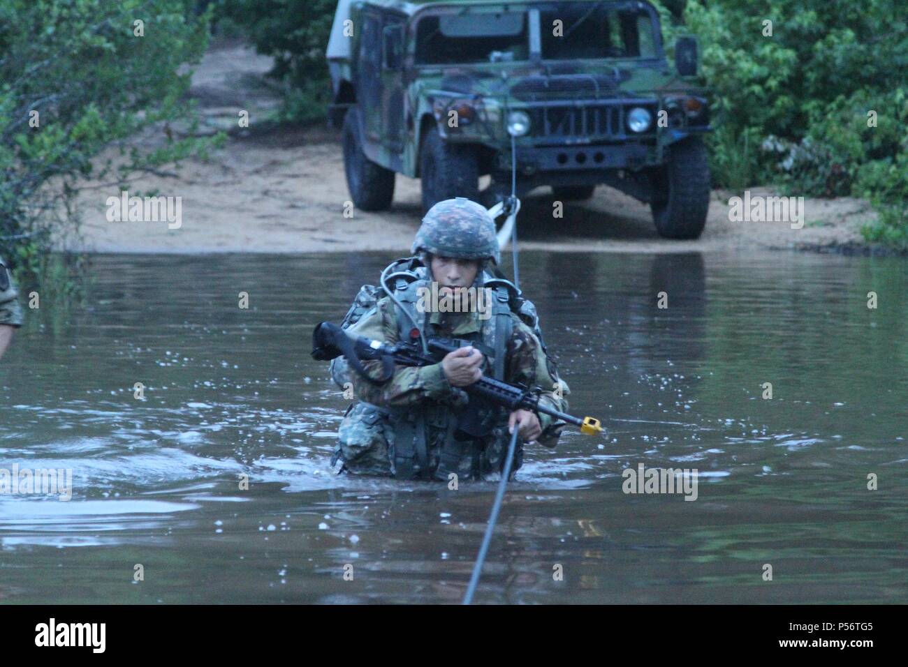 U.S. Army Reserve Spc, June 12, 2018. Nicholas Cholula, a combat documentation production specialist representing the 311th Signal Command Theater Support Unit crosses the river during the ruck march event at the 2018 U.S. Army Reserve Best Warrior Competition at Fort Bragg, North Carolina, June 12, 2018. The grueling, multifaceted competition evaluated U.S. Army Reserve Soldiers in the ruck march, the Excellence in Competition pistol range, the German Armed Forces Proficiency Badge and several other events with more challenges to come. (U.S. Army Reserve photo by Sgt. Rachel A. Leis) (Release Foto Stock