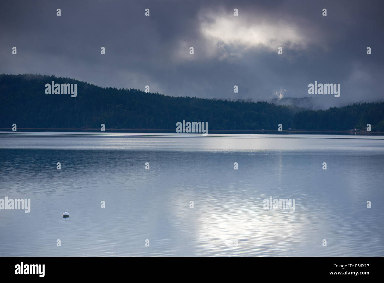 Nuvole temporalesche riflettere nelle acque del canale del cofano, Washington Foto Stock