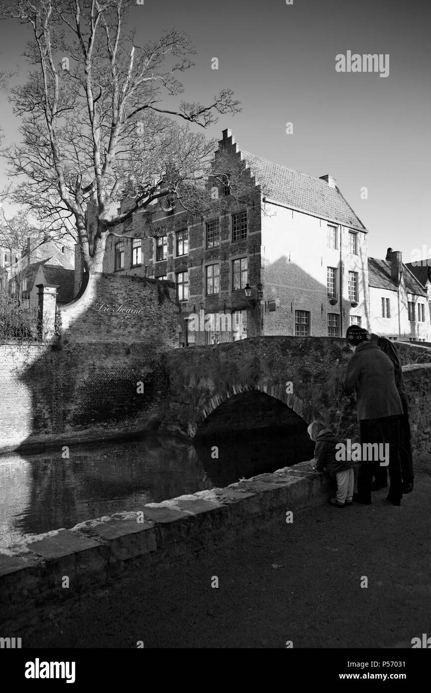 Meebrug: un vecchio ponte sul canal Goenerei in fondo Meestraat, Brugge, Belgio: una giovane famiglia guardare l'acqua. Versione in bianco e nero Foto Stock