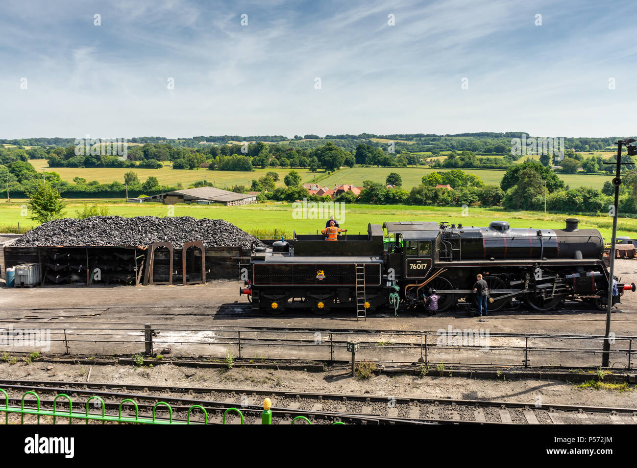 Locomotiva a vapore BR '4MT' 2-6-0 n. 76017 con la campagna inglese e in fondo alla linea di crescione Ropley, Hampshire, Inghilterra, Regno Unito Foto Stock