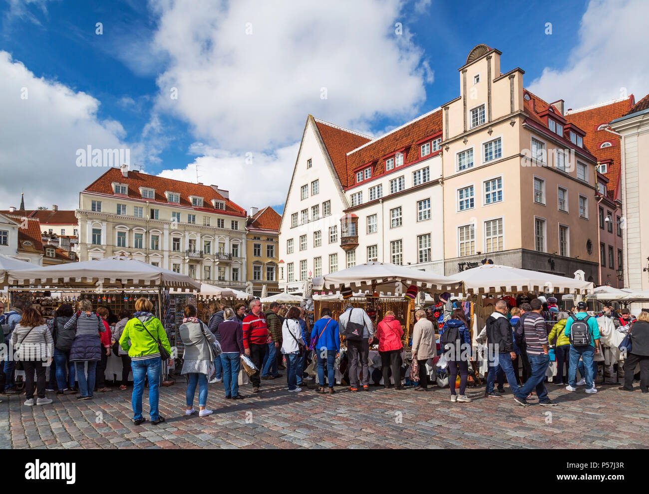 Il vecchio xviii secolo facciate con tetti in terracotta, di mercato con i turisti e i fornitori di souvenir, la piazza del Municipio di Tallinn, Estonia Foto Stock