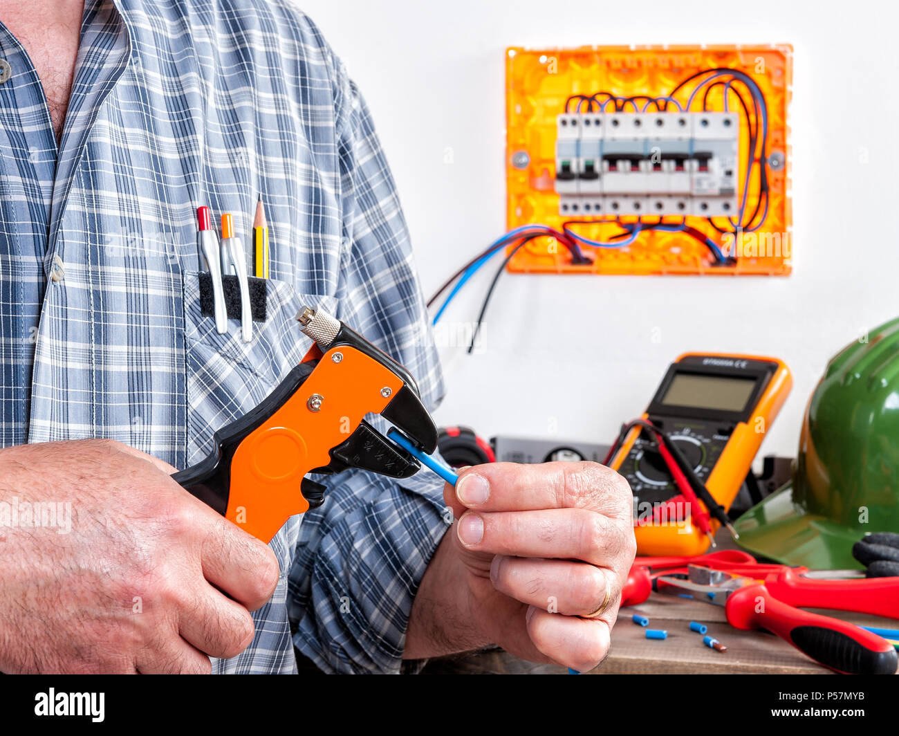 Elettricista tecnico al lavoro con spelafili su cavi in una zona  residenziale di installazione elettrica Foto stock - Alamy