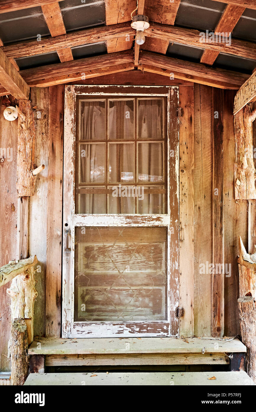 Antica in legno porta dello schermo in un vintage cabina con un portico coperto nelle zone rurali di Alabama, Stati Uniti d'America. Foto Stock