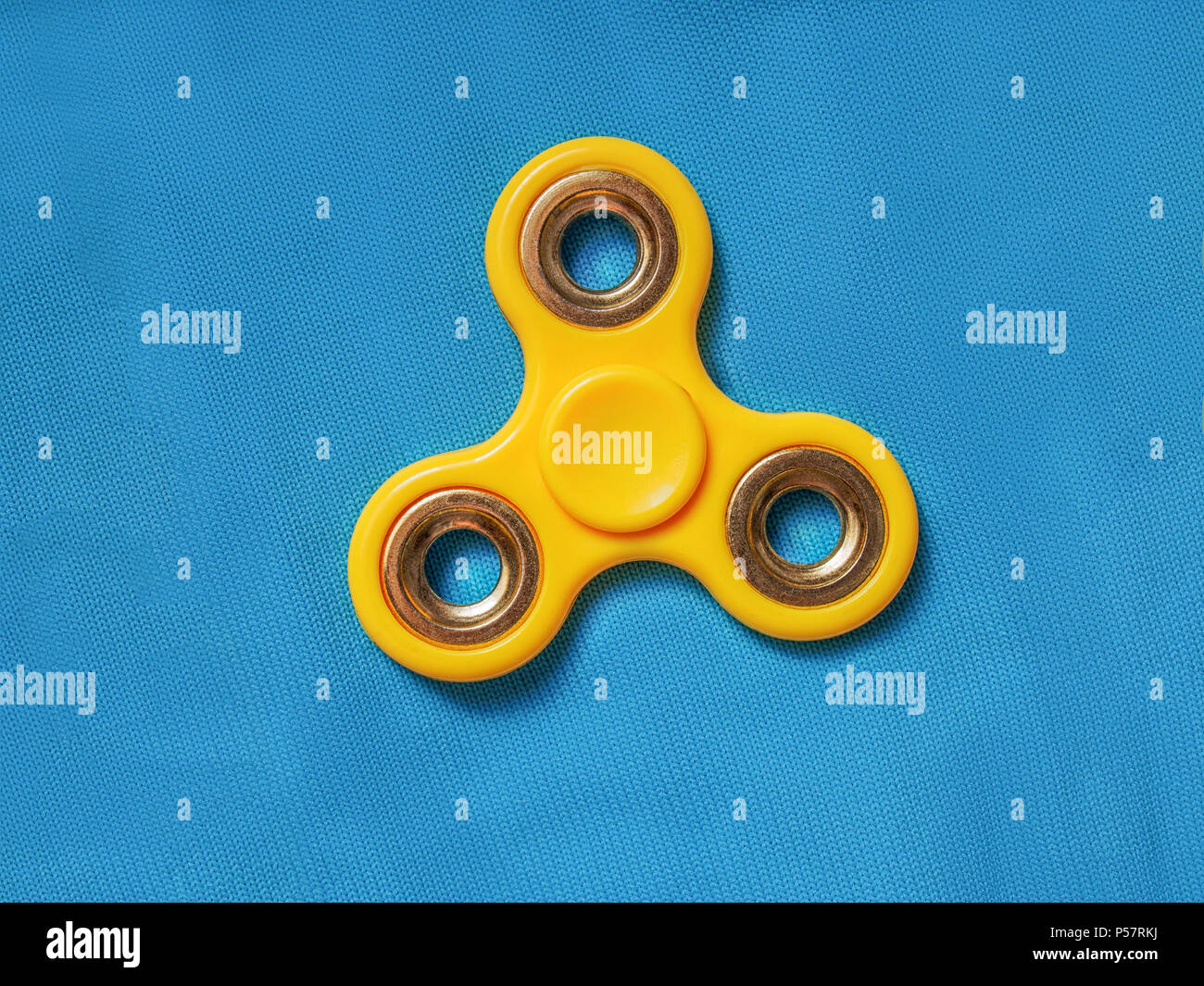 Giallo agitano: spinner sul tessuto blu sullo sfondo Foto Stock