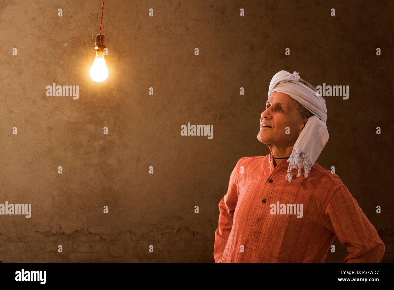 Il vecchio contadino felice guardando le lampadine di casa sua Foto Stock