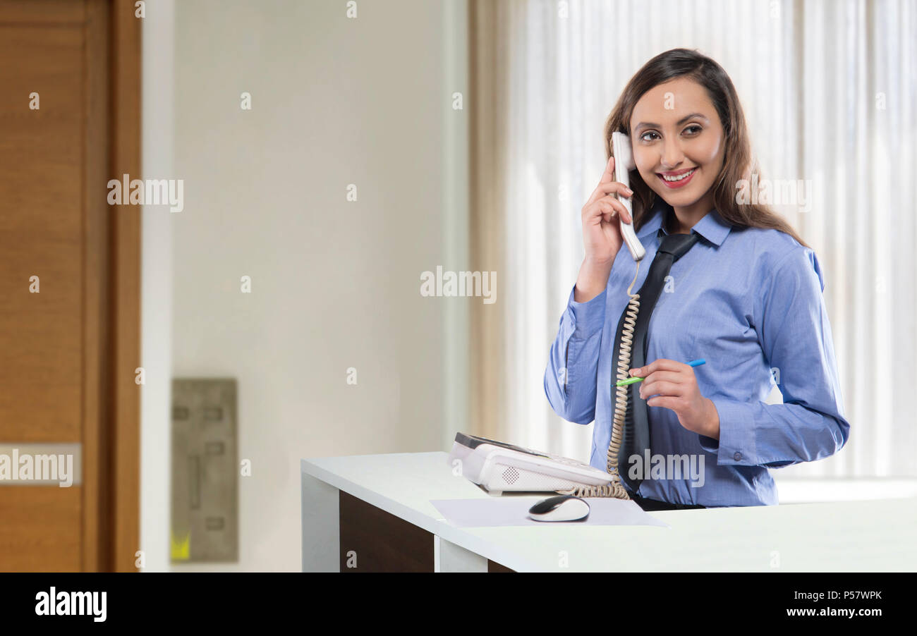 Receptionist parlare al telefono Foto Stock