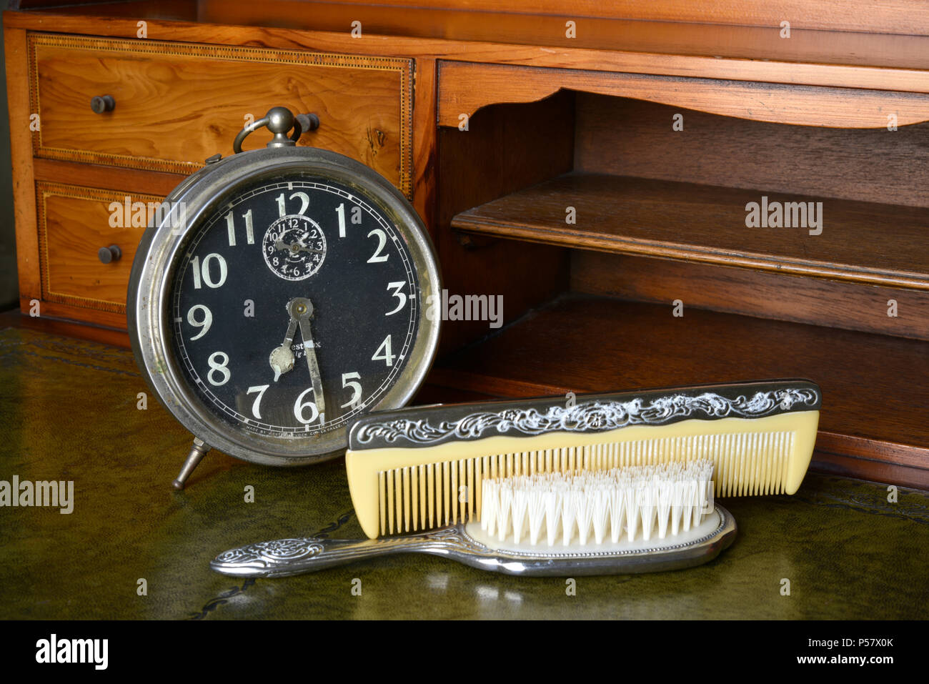 Vintage orologio sveglia con argento vecchio pettine e spazzola per capelli  su un'antica scrivania in legno Foto stock - Alamy
