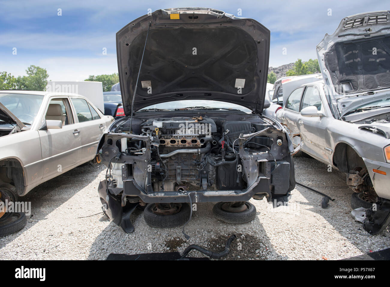 Il vano motore del relitto di una vettura rivela parti mancanti, compresi il paraurti, il radiatore e la parte del motore Foto Stock