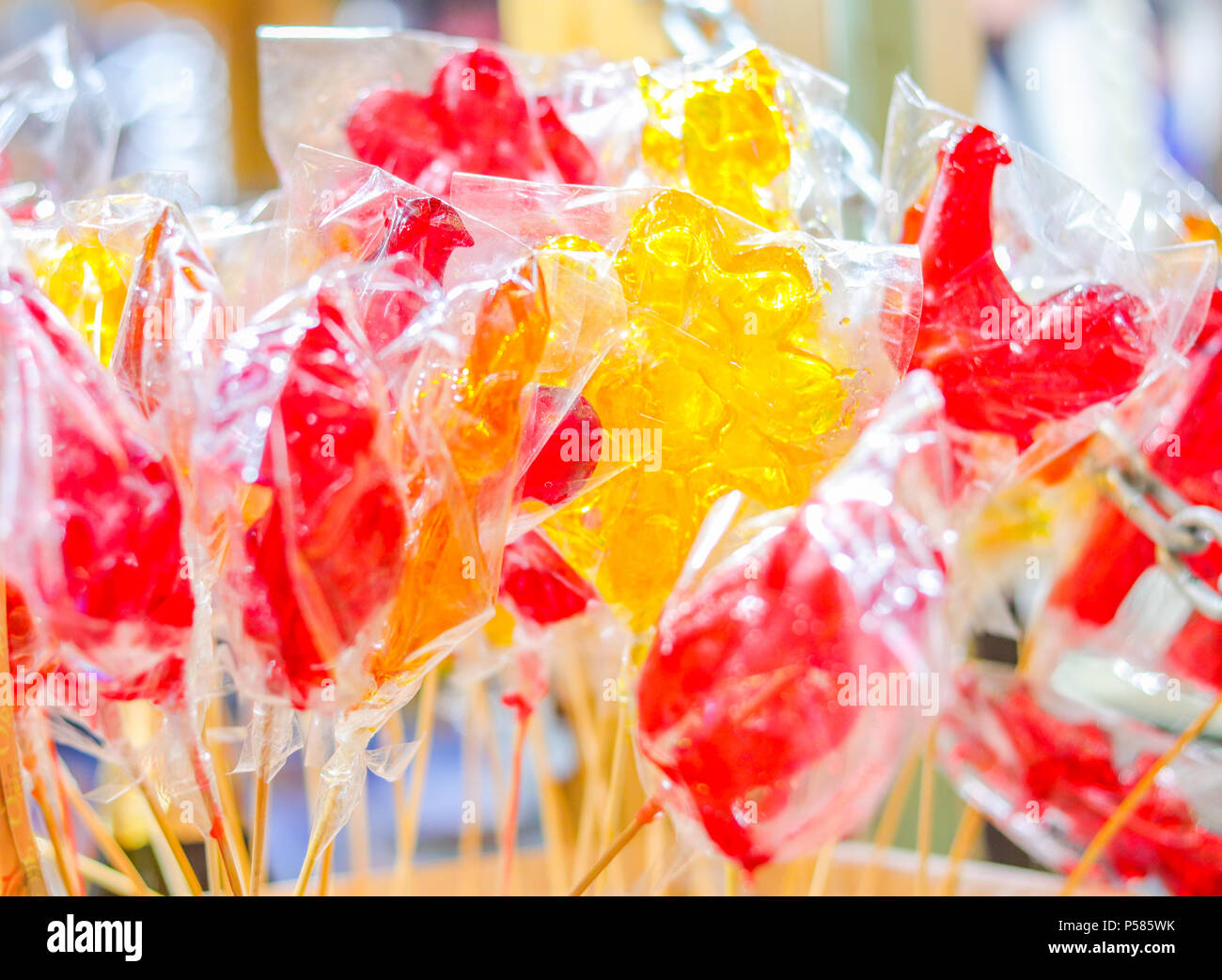 Lecca lecca i galletti su bastoni di colore giallo e rosso. Cucina di strada Foto Stock