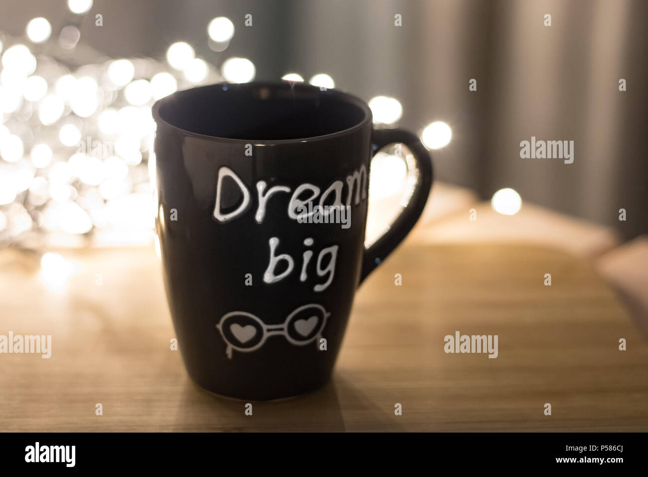 Grande Sogno mug sulla cima di legno e le luci bokeh sullo sfondo Foto Stock