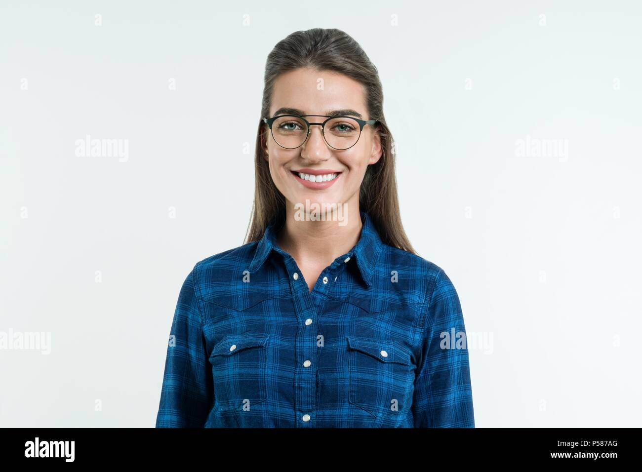 Ritratto di giovane donna positiva con rettilinei lunghi capelli, occhi blu e un bel sorriso, ponendo in studio su sfondo bianco. Persone, happine Foto Stock