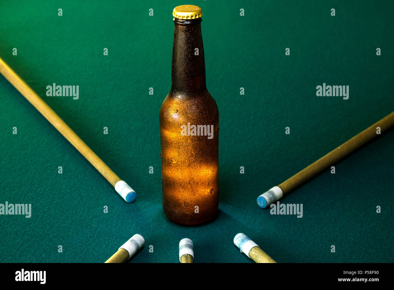 Quattro bastoni di cue su un verde tavolo da biliardo Foto Stock