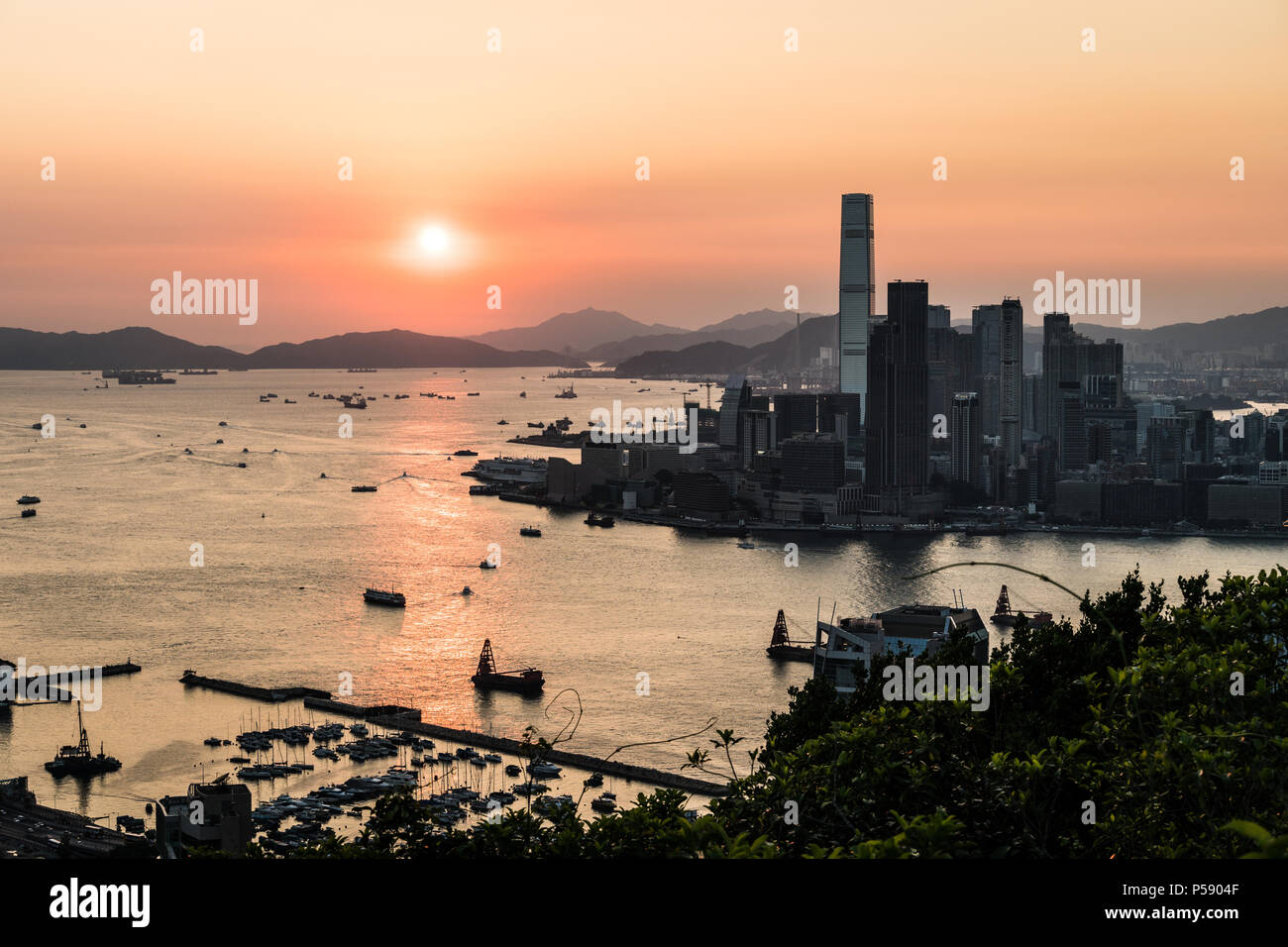 Splendida vista del tramonto sopra il porto di Victoria in Hong Kong con il grattacielo di Kowloon Tsim Sha Tuis waterfront a sinistra in Cina Foto Stock