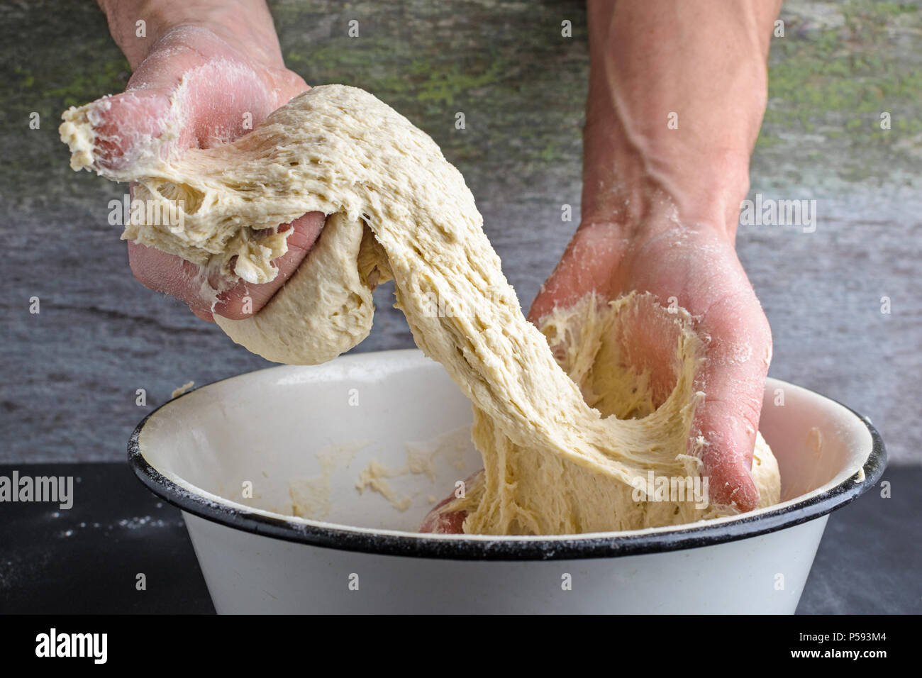 Gli uomini con le mani in mano maling la pasta su una tavola di legno Foto Stock