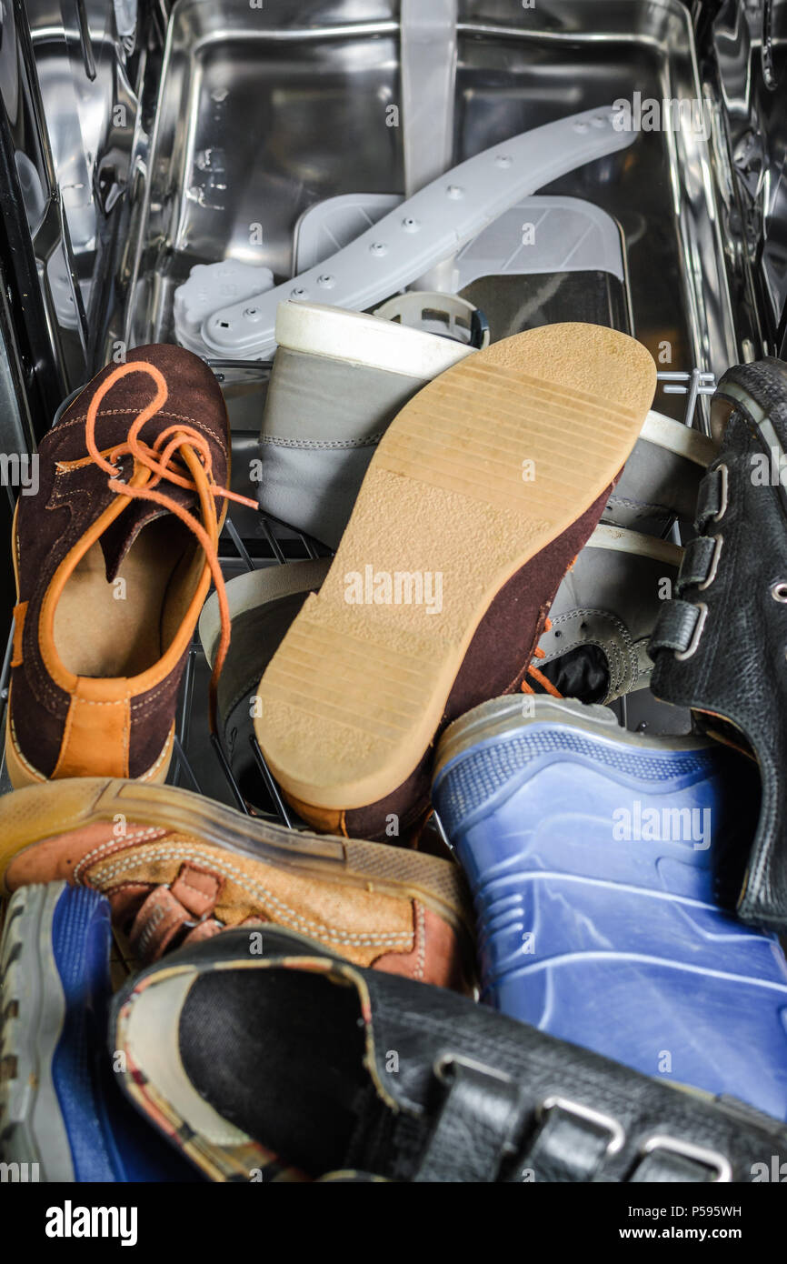 Un sacco di vecchie scarpe caricato in lavastoviglie. Uso improprio degli elettrodomestici Foto Stock