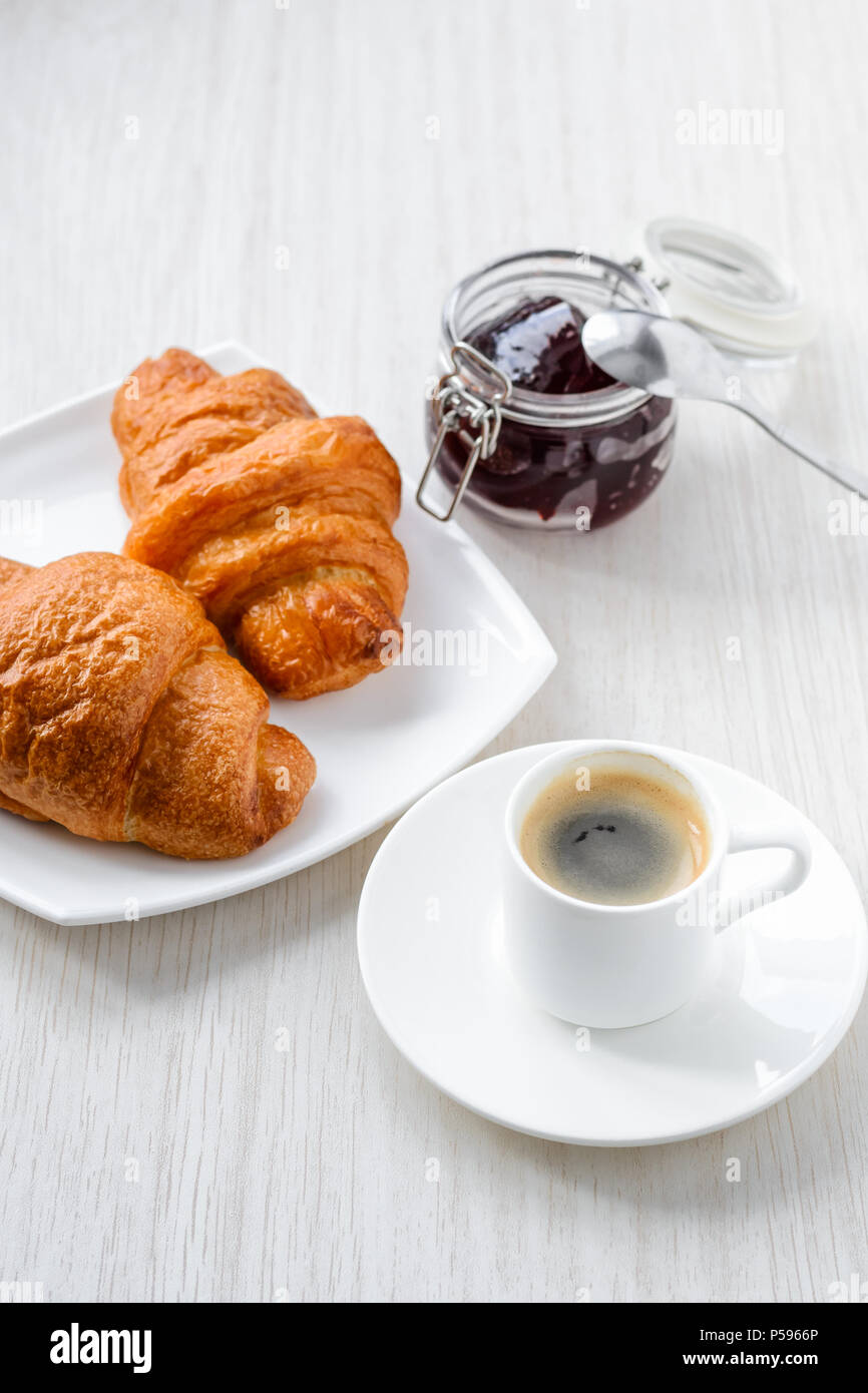 La colazione del mattino. Caffè, cornetti e marmellata su sfondo bianco, vista dall'alto Foto Stock