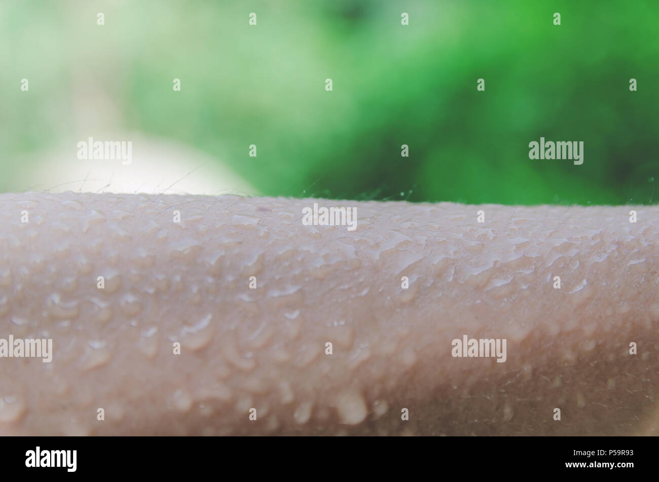 Ravvicinata di una goccia di acqua sulla pelle umana per lavare e pulire la pelle, acqua diffusa e la gocciolina di acqua sul braccio della pelle, pelle umana con acqua goccia un Foto Stock