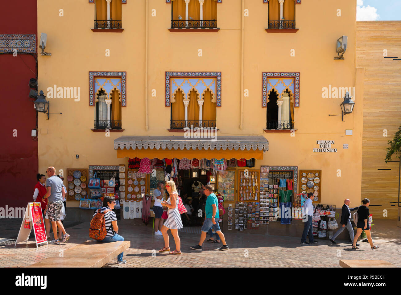 Andalucia Spagna turismo, i visitatori estivi della città di Cordoba passano un negozio di articoli da regalo turistico in Plaza del Triunfo, Andalusia, Spagna. Foto Stock