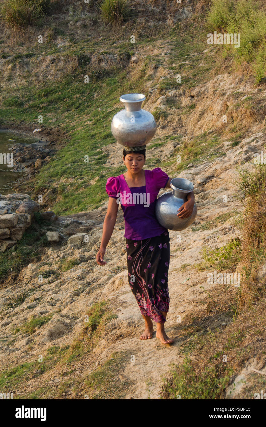 La donna è stata portando vasi d'acqua da fonti Foto Stock