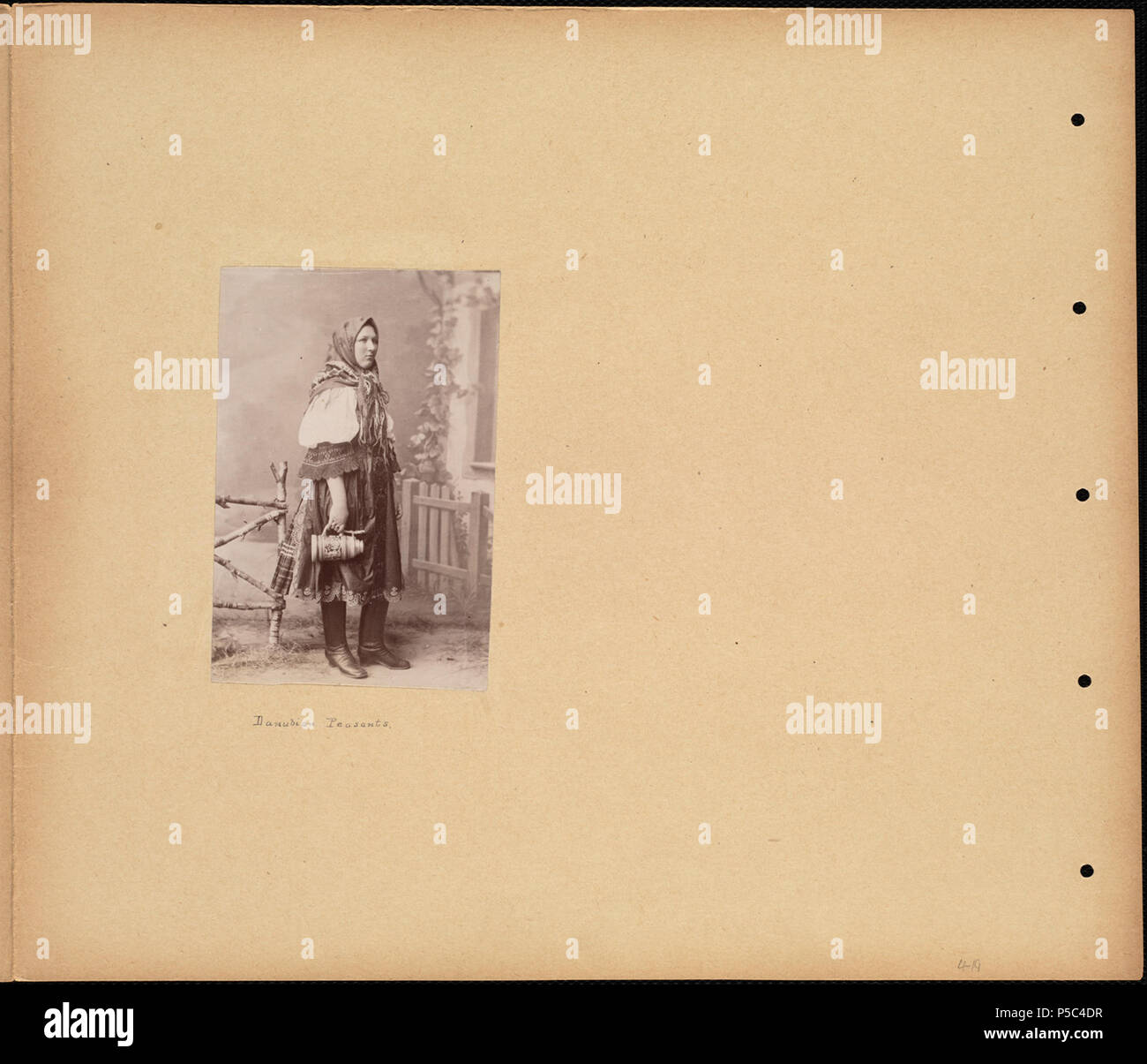 N/A. Inglese: BPLDC N°: 08 04 000465 Titolo pagina: danubiano contadina in abito tradizionale raccolta: Tupper fotodiari Collezione Album: Volume 4: Austria. Chiamata n.: 4098B.104 v4 (p. 19) creatore: Tupper, William Vaughn Genere: fotodiari; albume stampe misura: 1 stampa fotografica montata su pagina : albume ; pagina 33 x 39 cm. Descrizione: Scrapbook pagina contiene una fotografia che mostra un contadino danubiano vestito in costumi tradizionali. Indossa uno scialle sul suo capo e detiene un Stein. Trascrizione: danubiano contadini. Note: pagina descrizione fornita da cataloger, derivata da didascalie e Foto Stock
