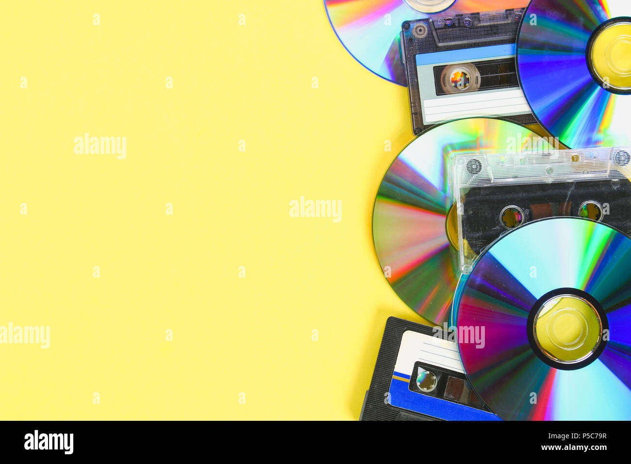 I dischi CD e cassette audio su un pastello giallo dello sfondo. Il minimalismo Foto Stock