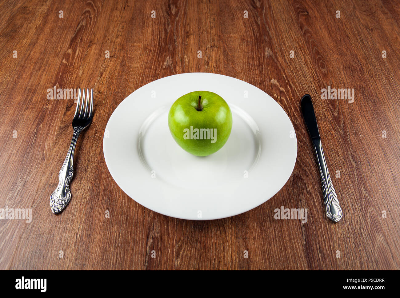 Tabella appuntamenti e la fresca mela verde su una piastra bianca close up Foto Stock