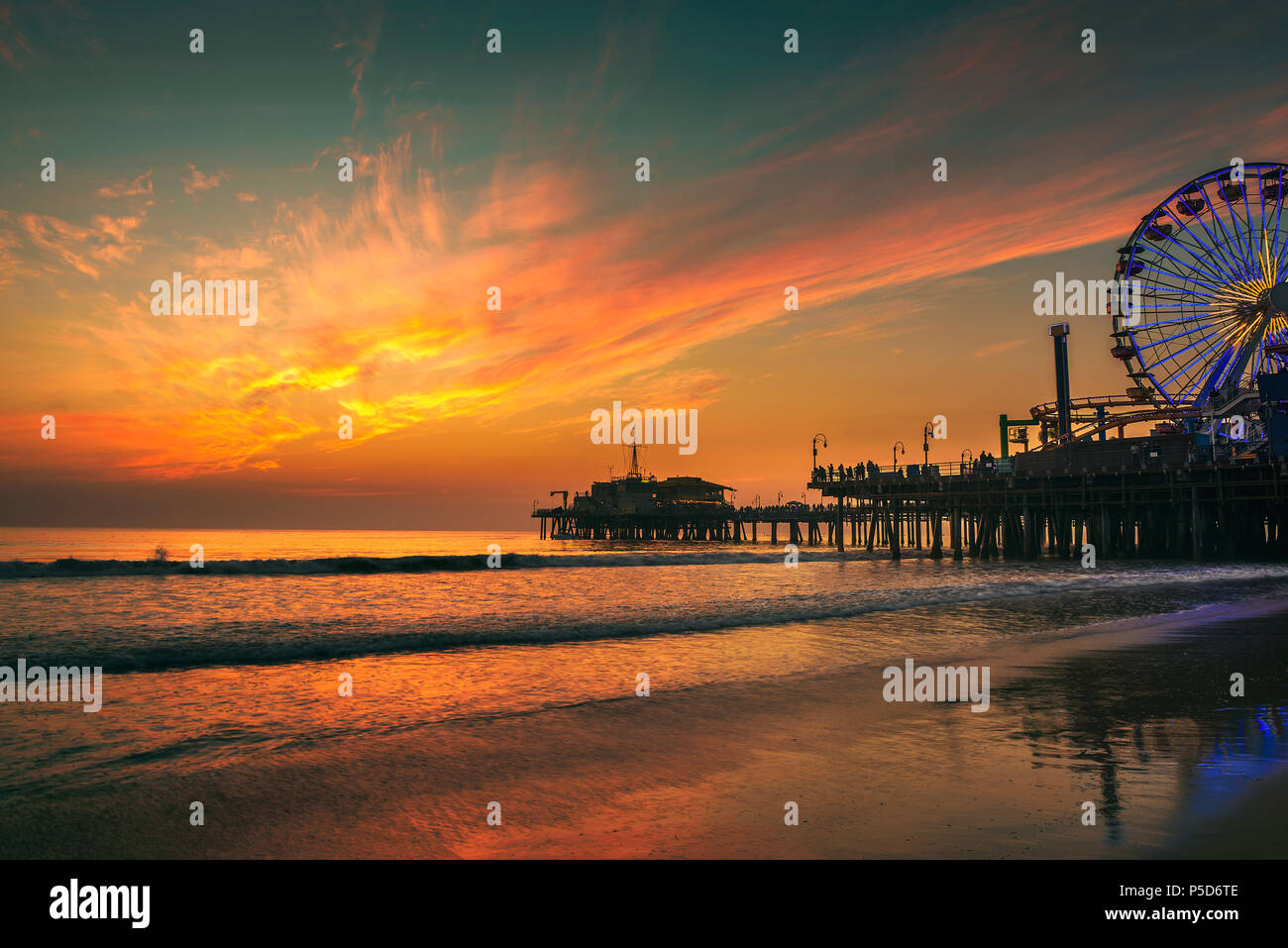 I visitatori godere il tramonto sopra Santa Monica Pier a Los Angeles Foto Stock