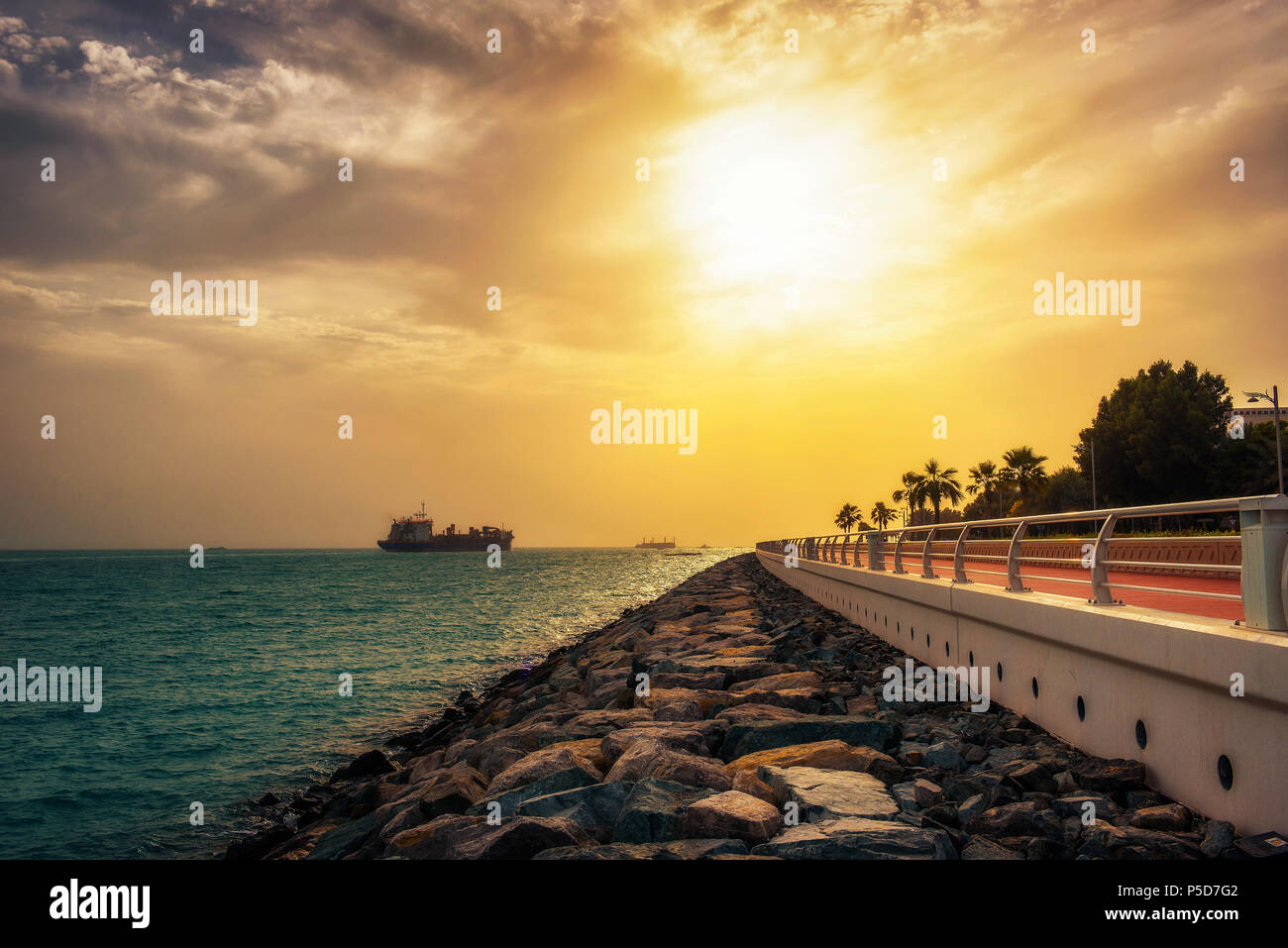 Contenitore di carico nave lasciando Dubai Marina al tramonto Foto Stock