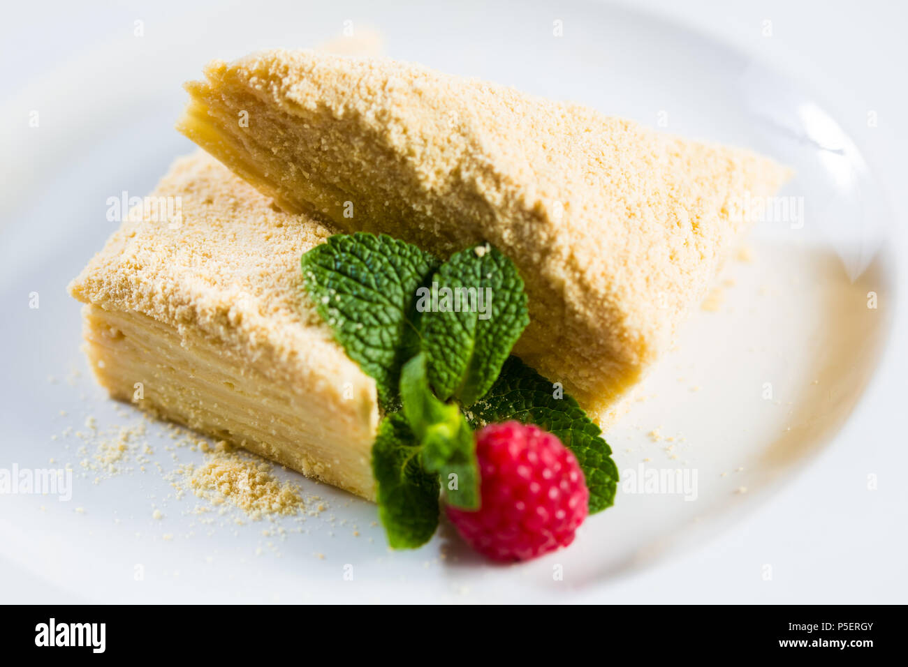 Napoleone torta di pasta sfoglia con panna acida su una piastra. Foto Stock