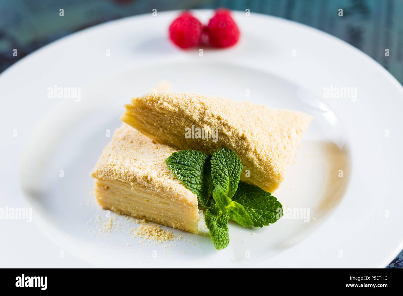 Napoleone torta di pasta sfoglia con panna acida su una piastra. Foto Stock
