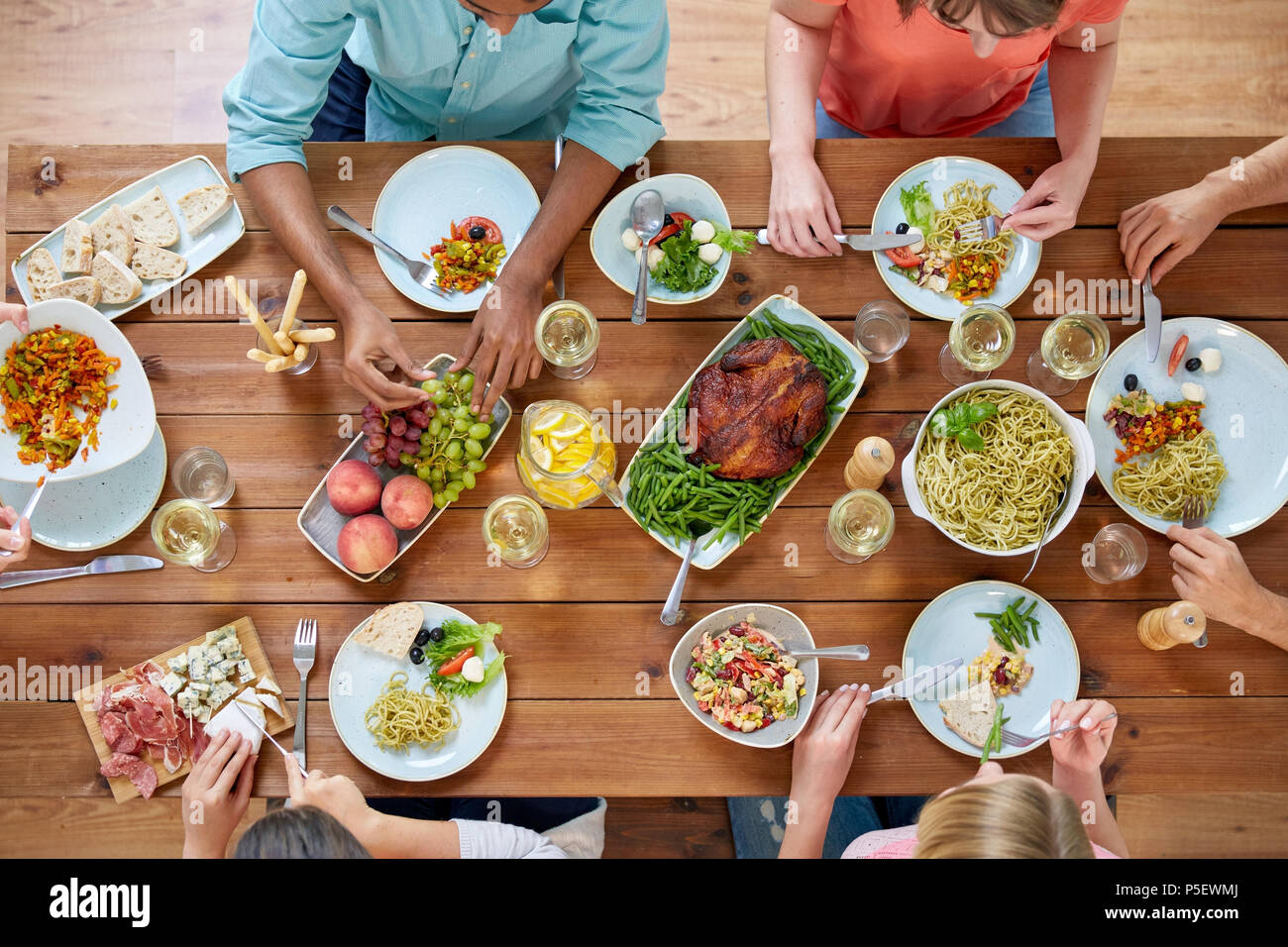 Gruppo di persone mangiare a tavola con i prodotti alimentari Foto Stock