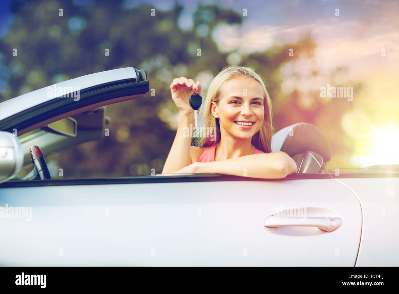 Felice giovane donna con autovettura convertibile key Foto Stock