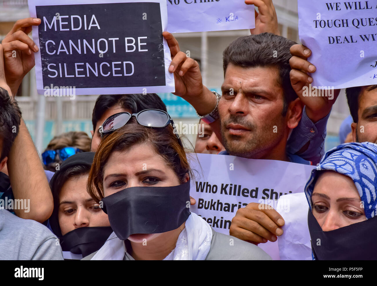 Il Kashmir giornalisti coprono i loro volti durante la protesta. I giornalisti hanno tenuto una manifestazione contro l'uccisione della giornalista senior Shujaat al-Bukhari in Srinagar. Al-Bukhari è stato ucciso dalla pistola non identificato gli uomini nelle pagine precedenti di questo mese. I giornalisti sono stati anche esigente di una sonda nel controverso osservazioni fatte dal Bharatiya Janata Party gli stati e lo stato di diritto maker Lal Singh seguenti al-Bukhari uccidere. Foto Stock