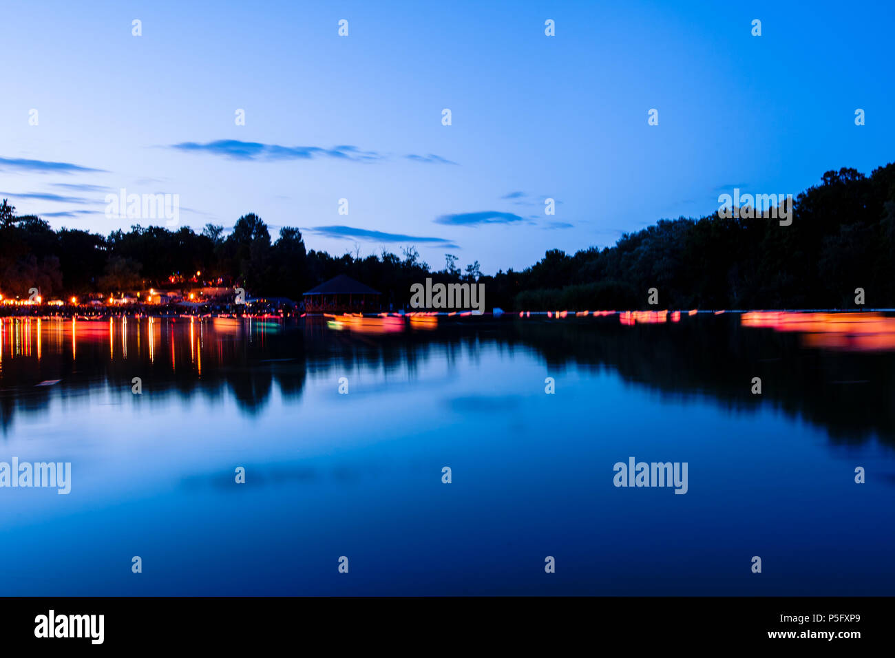 Desidero lanterne riflessioni con le candele accese sul lago a notte d'estate. I tempi di esposizione lunghi Foto Stock