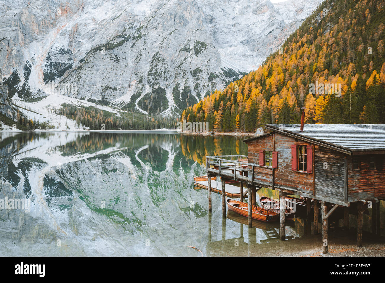 Vista panoramica di legno tradizionali boathouse al famoso Lago di Braies con montagna dolomiti di picchi che si riflettono nel lago, Alto Adige, Italia pisello di montagna Foto Stock