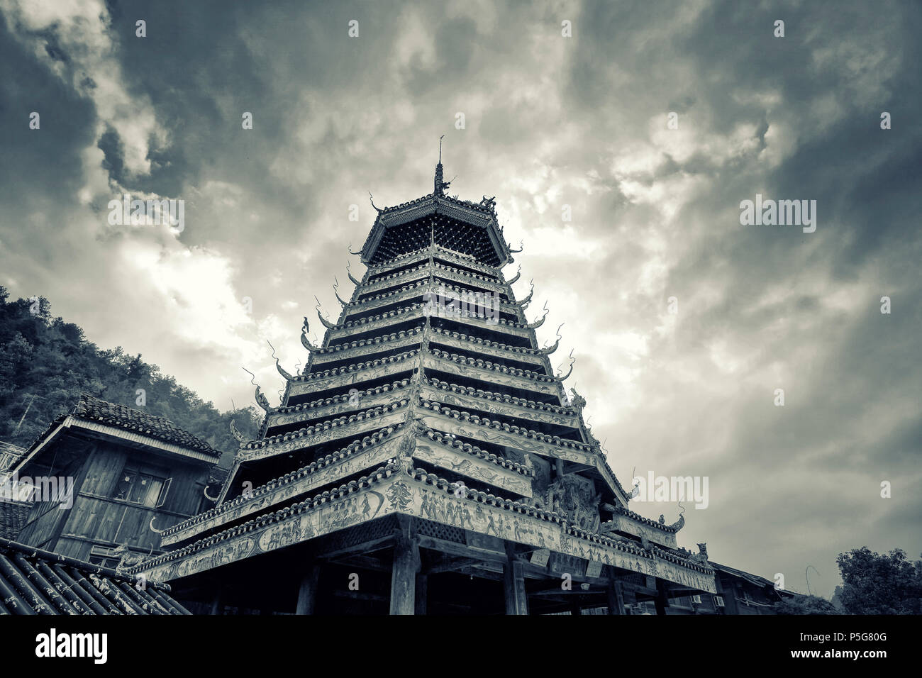 In un vecchio villaggio Miao a Guizhou, Cina, la gente ha costruito questa torre di Santo al culto dei loro antenati. Cielo di sfondo mostra tempesta si sta avvicinando. Foto Stock