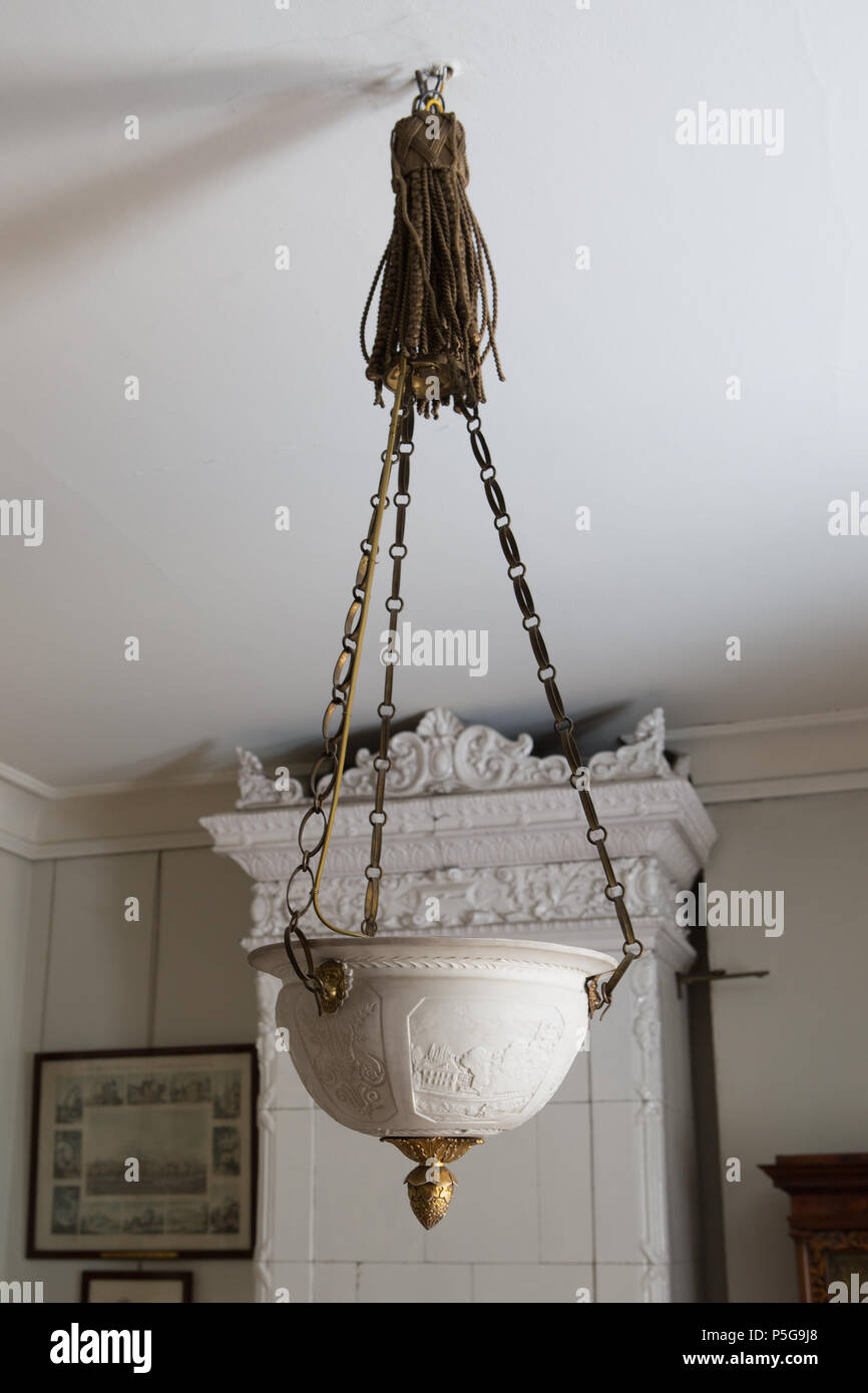. Nota: per scopi documentali la descrizione originale è stato conservato. Correzioni fattuali e descrizioni alternative sono incoraggiati separatamente dalla descrizione originale. Ampel ho husan Annas rum Nyckelord: Lampa, Ampel, Lykta. Ampel . Svenska: AMPEL porslin Av och mässing. Bestående av en nästan halvsfärisk porslinsskål med utsvängd brädd över en grund käl. Ho bottens mitt en kupig bladrosett samt en kottformig hängknopp (rosett och knopp förgyllda). Skålen hängande i tre långa kedjor mässing av. Ampeln hängande i en kedja av 8-formiga platta länkar, kedjorna utanpå en stor tofs av Foto Stock