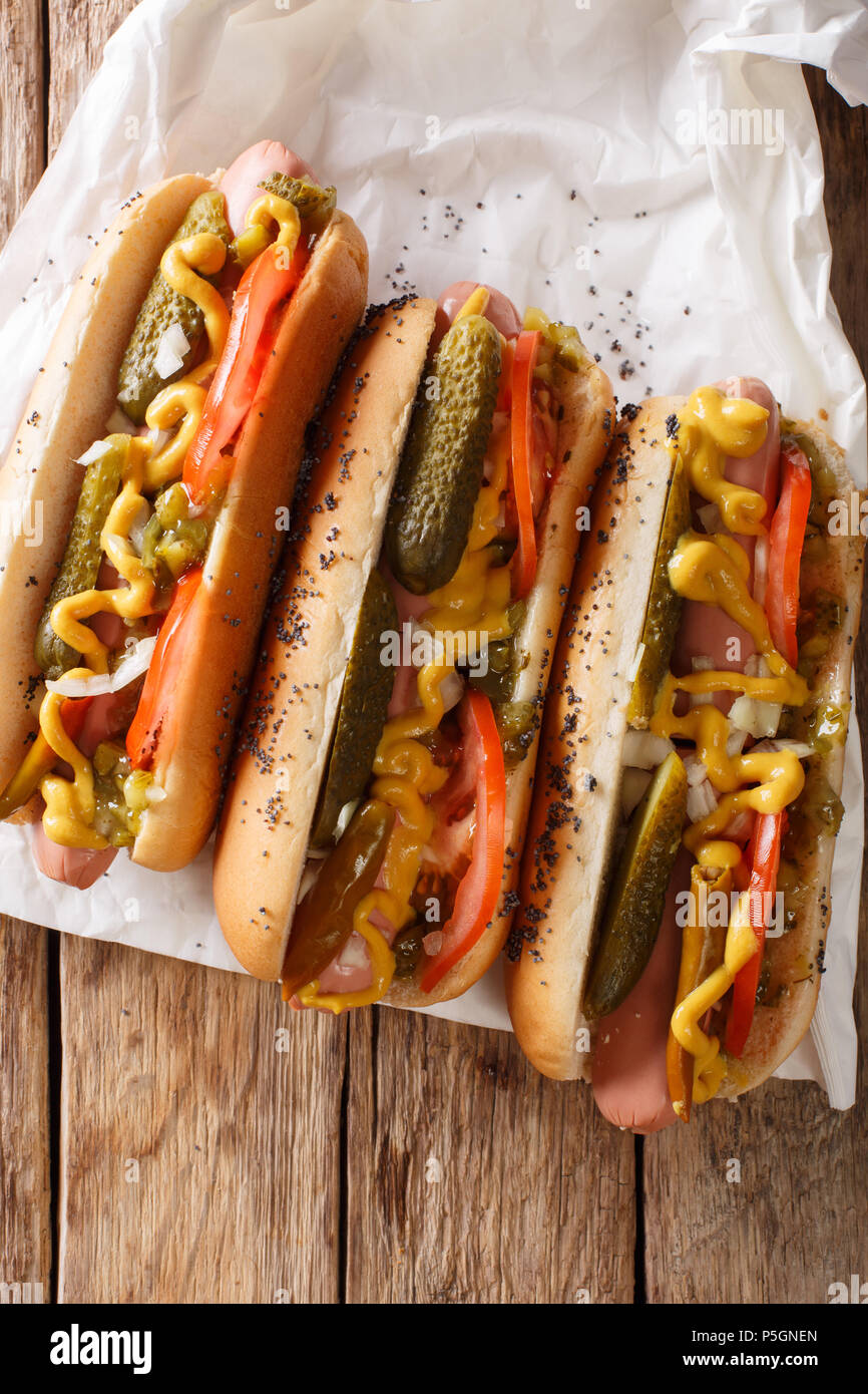 Delizioso stile di Chicago hot dog con senape, verdure e assaporare da vicino sul tavolo. verticale in alto vista da sopra Foto Stock