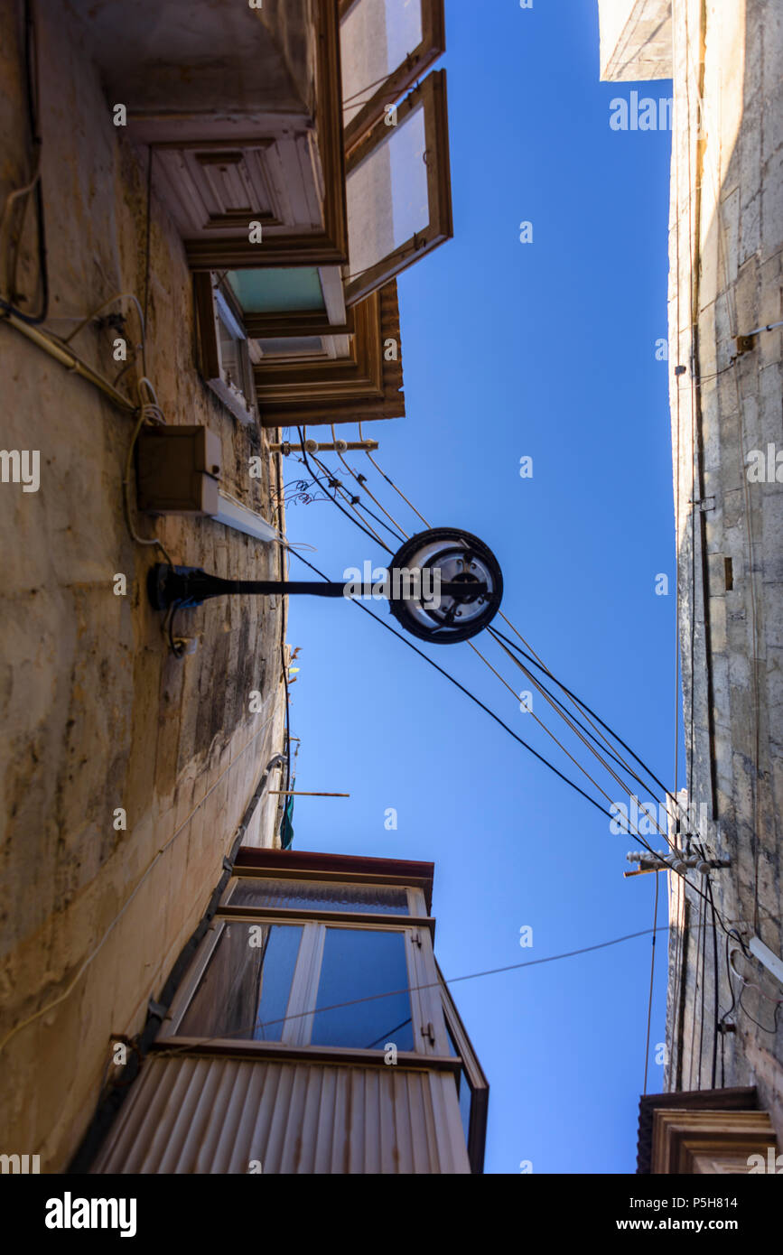 Illuminazione e linee di alimentazione sopra le strette viuzze nel Victoria Città Vecchia, Gozo, Malta. Foto Stock