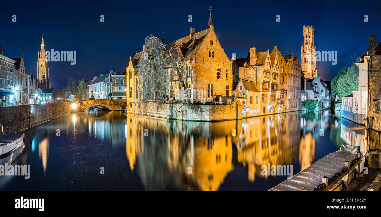 Classic vista da cartolina del centro storico della città di Brugge, a cui spesso viene fatto riferimento come la Venezia del Nord, illuminato al crepuscolo, Fiandre, in Belgio Foto Stock