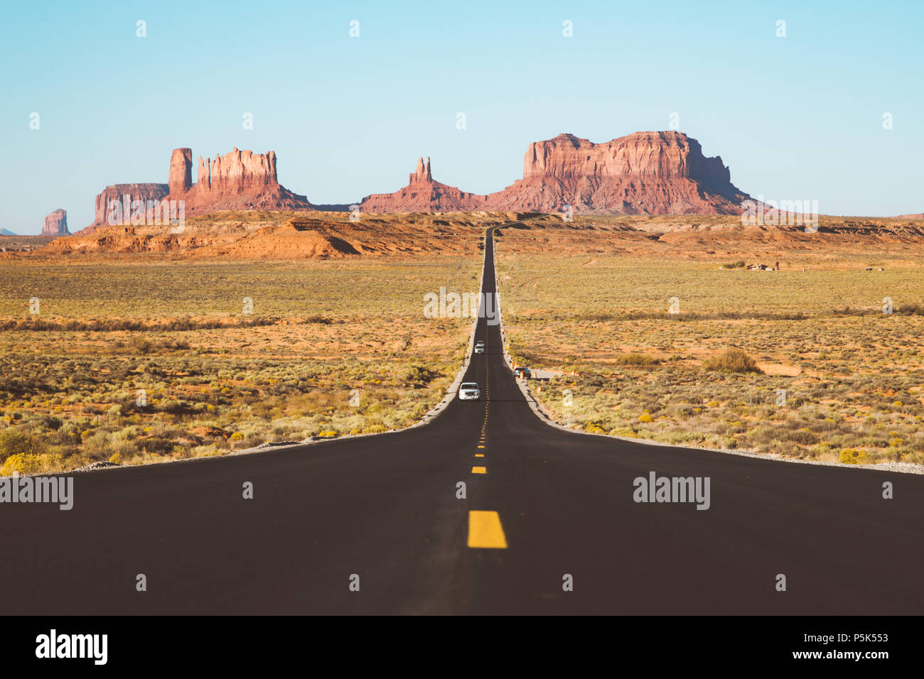 Classic vista panorama del centro storico di U.S. Percorso 163 in esecuzione attraverso la famosa Monument Valley in beautiful Golden luce della sera al tramonto in estate, STATI UNITI D'AMERICA Foto Stock