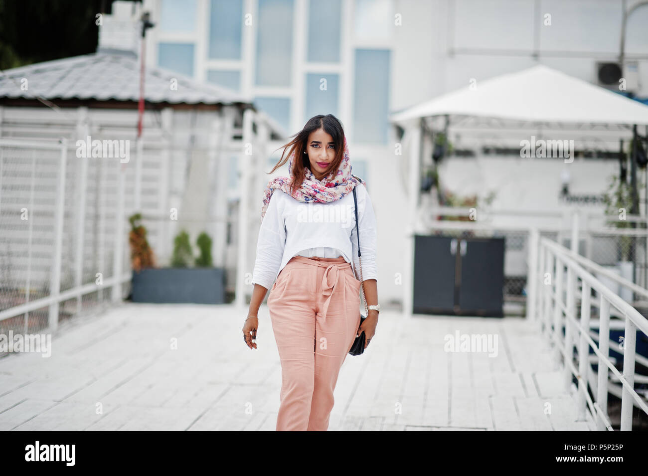 Moda ragazza araba in camicia bianca e pantaloni di pesche poste  all'esterno. Elegante donna musulmana Foto stock - Alamy