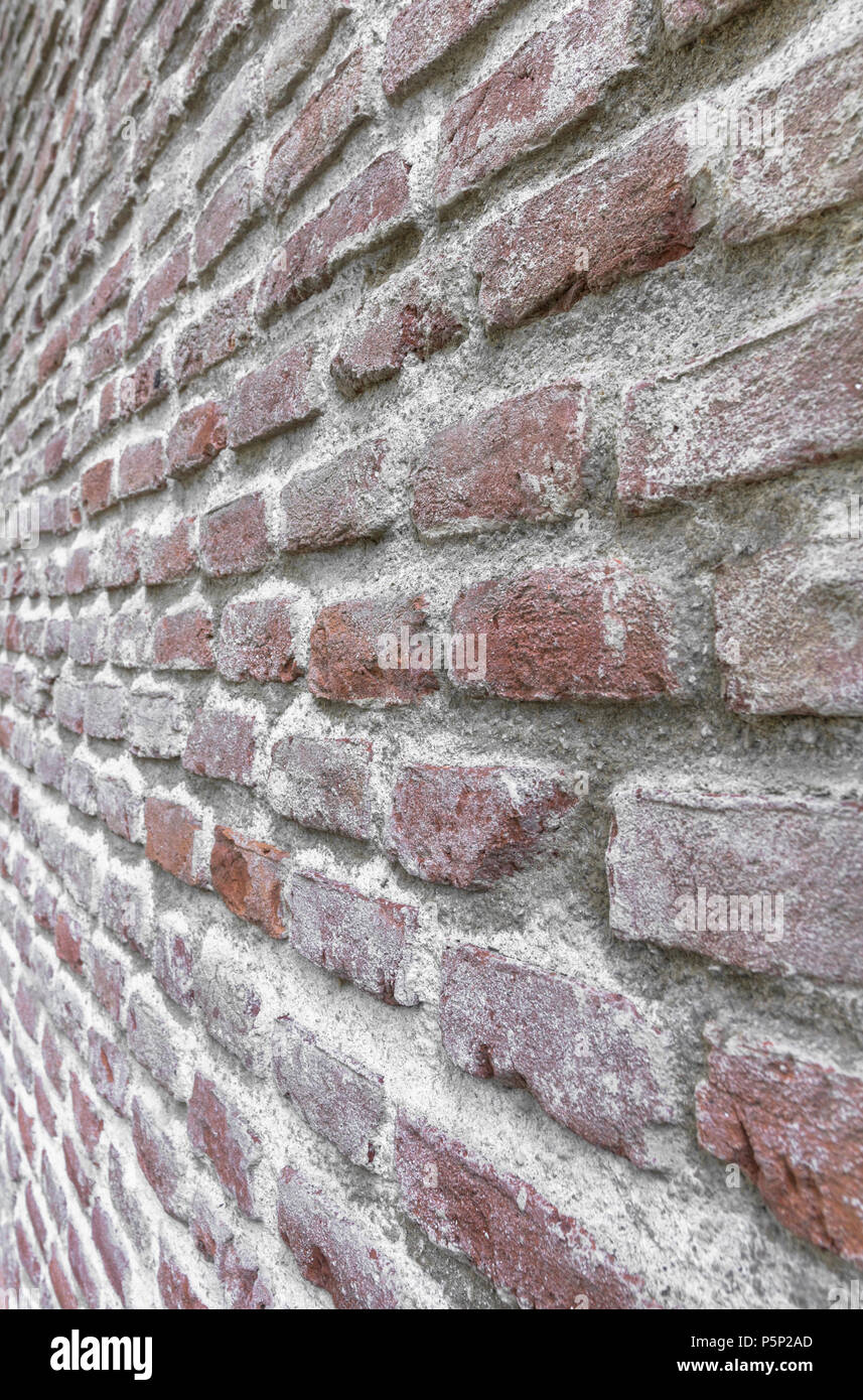 Rosso vecchio muro di mattoni. Angolo obliquo. Ideale per lo sfondo. Foto Stock